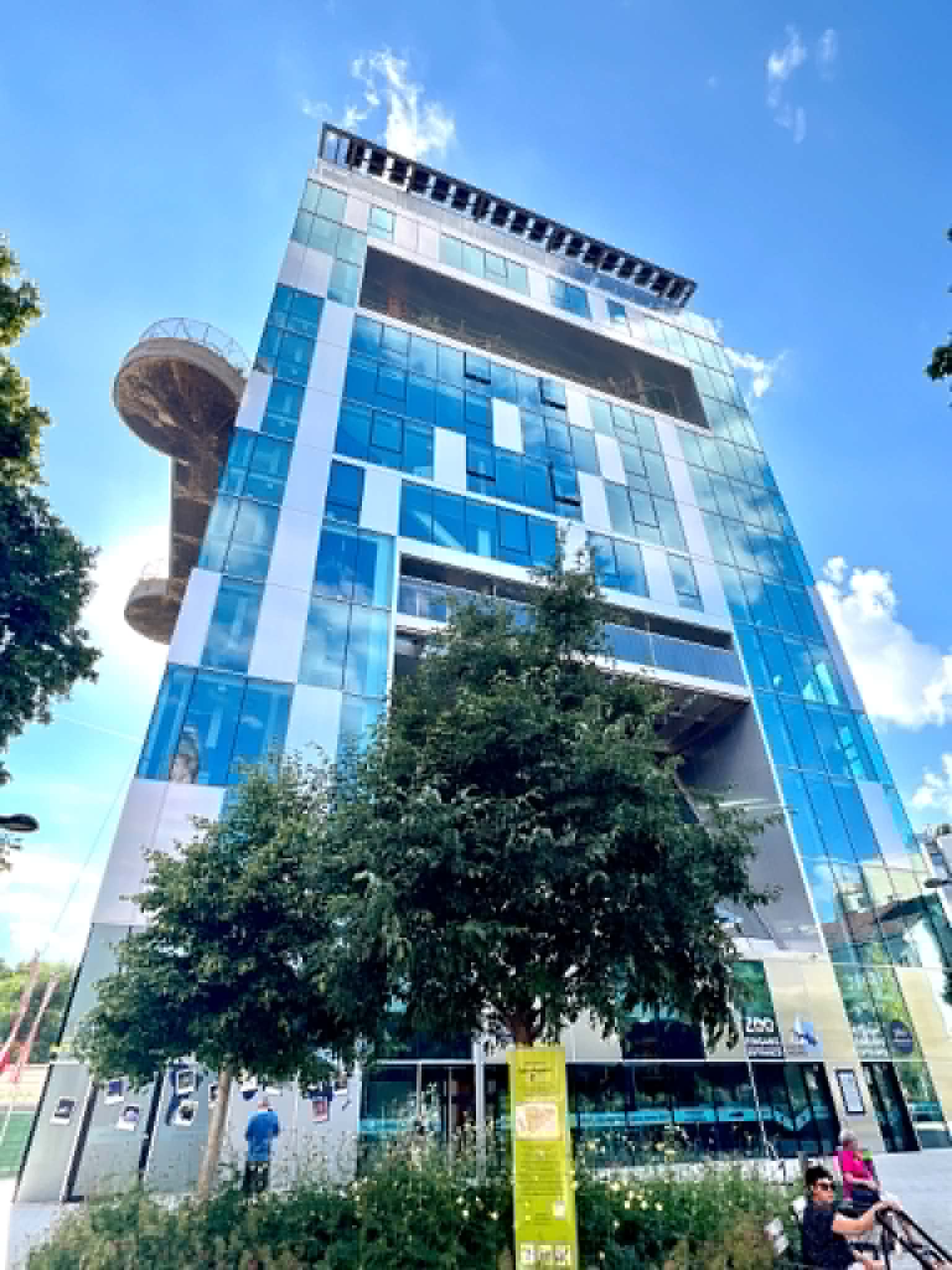 Glass building with rock climbing wall.