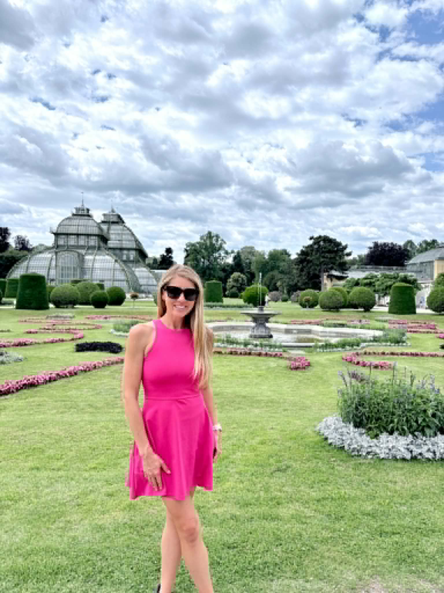 Women standing in palace garden.