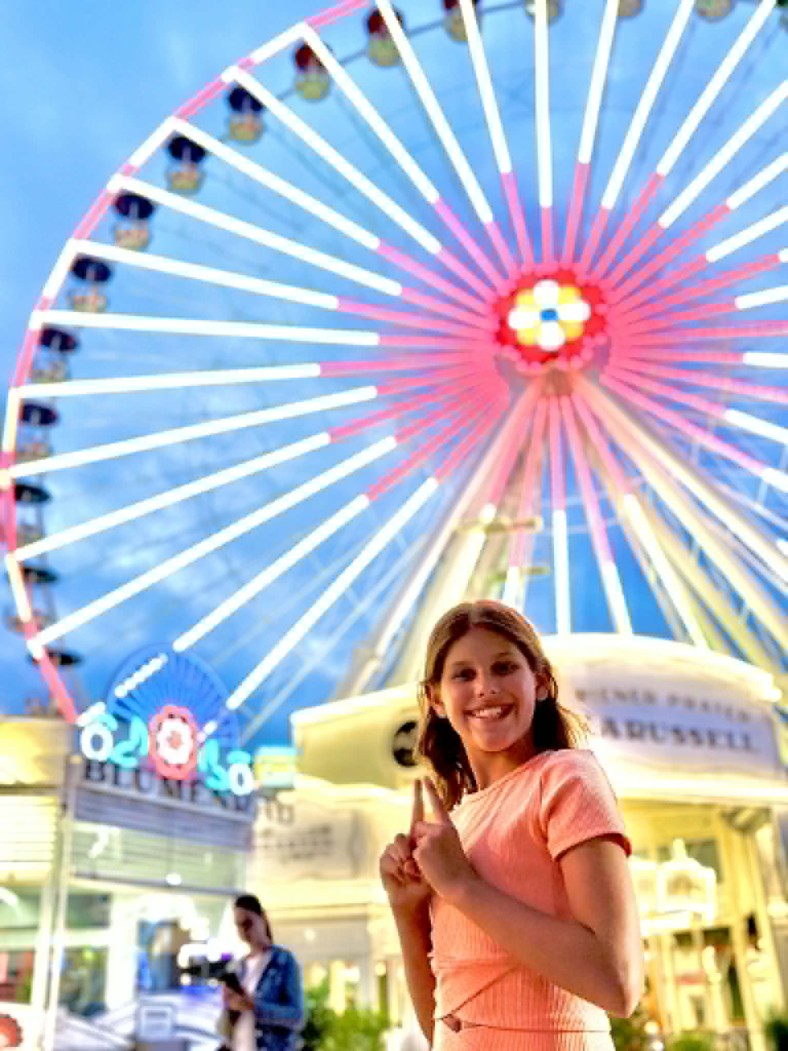 Girl in front, ferris wheel in back.