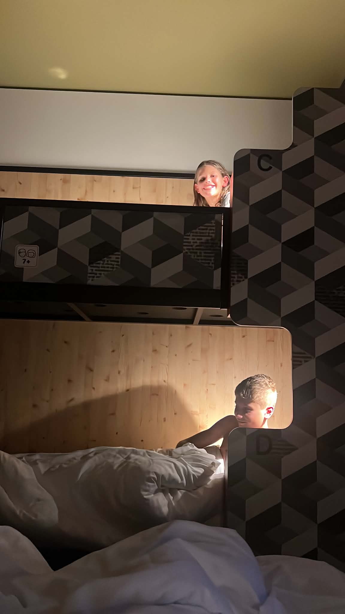 Two kids in their bunk beds at their Zurich hotel, Meininger.