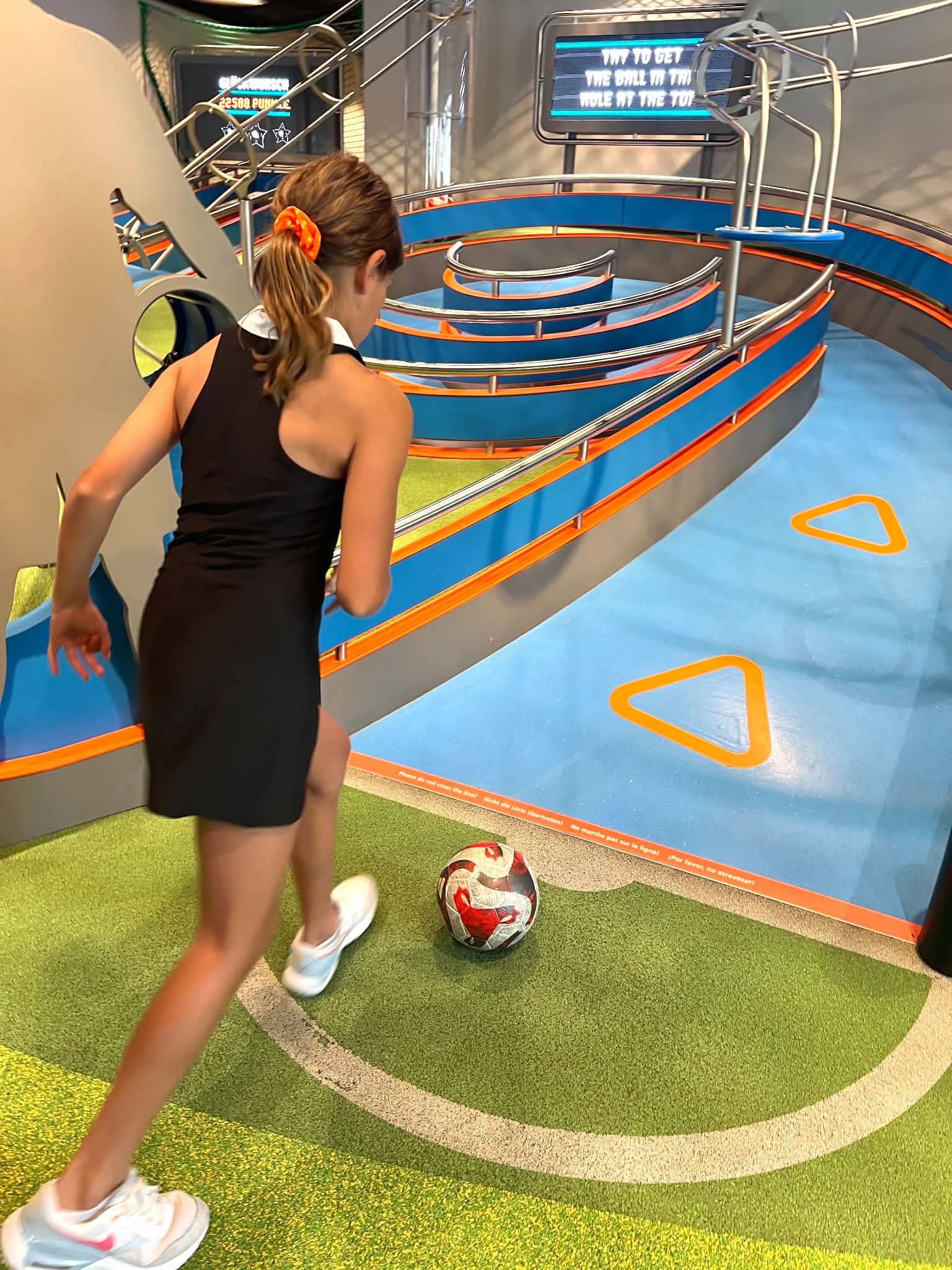 A little girl doing a soccer challenge at the FIFA Museum in Zurich, Switzerland.