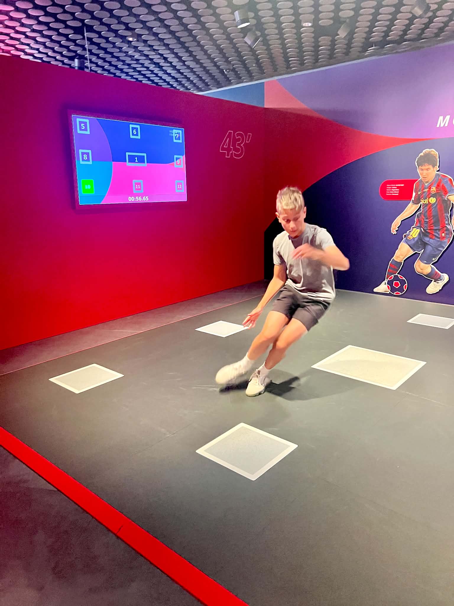 A teenage boy at the FIFA Museum doing a challenge to see if he can outperform Messi.