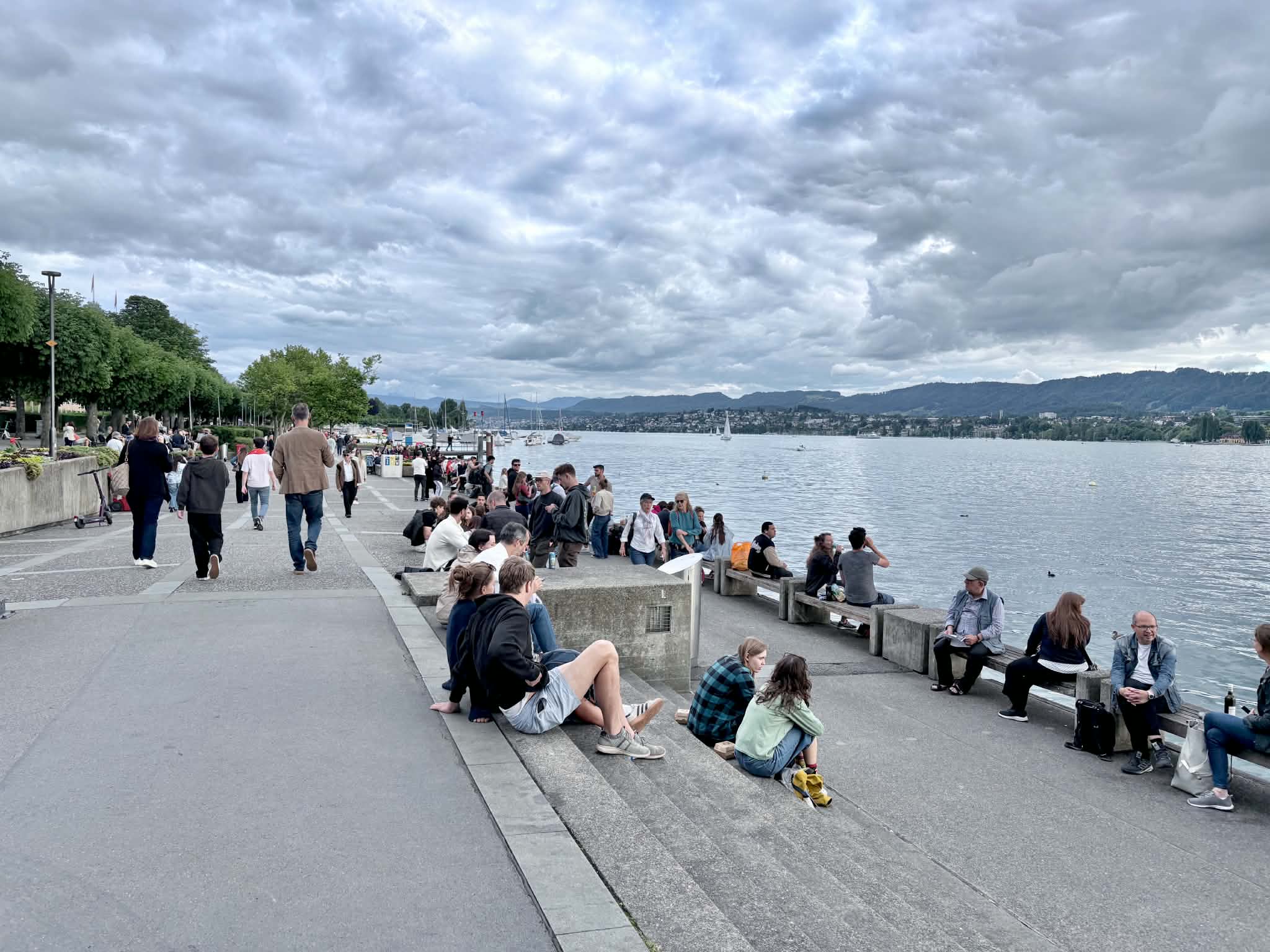 Lake Zurich Promenade lined with people enjoying the evening. Some families have their kids there too while visiting Zurich.