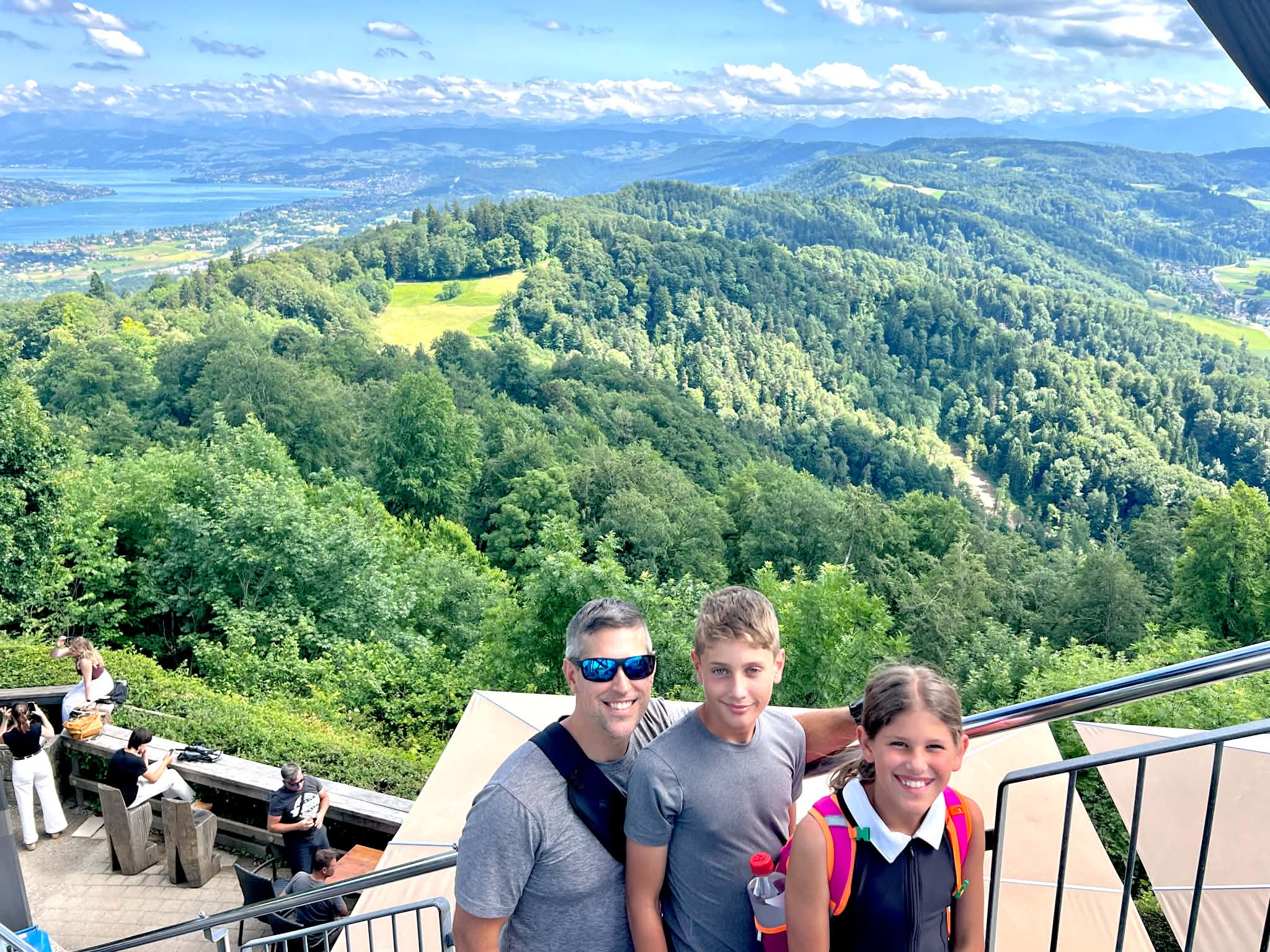 A dad in Zurich with kids overlooking the city and Switzerland mountains.