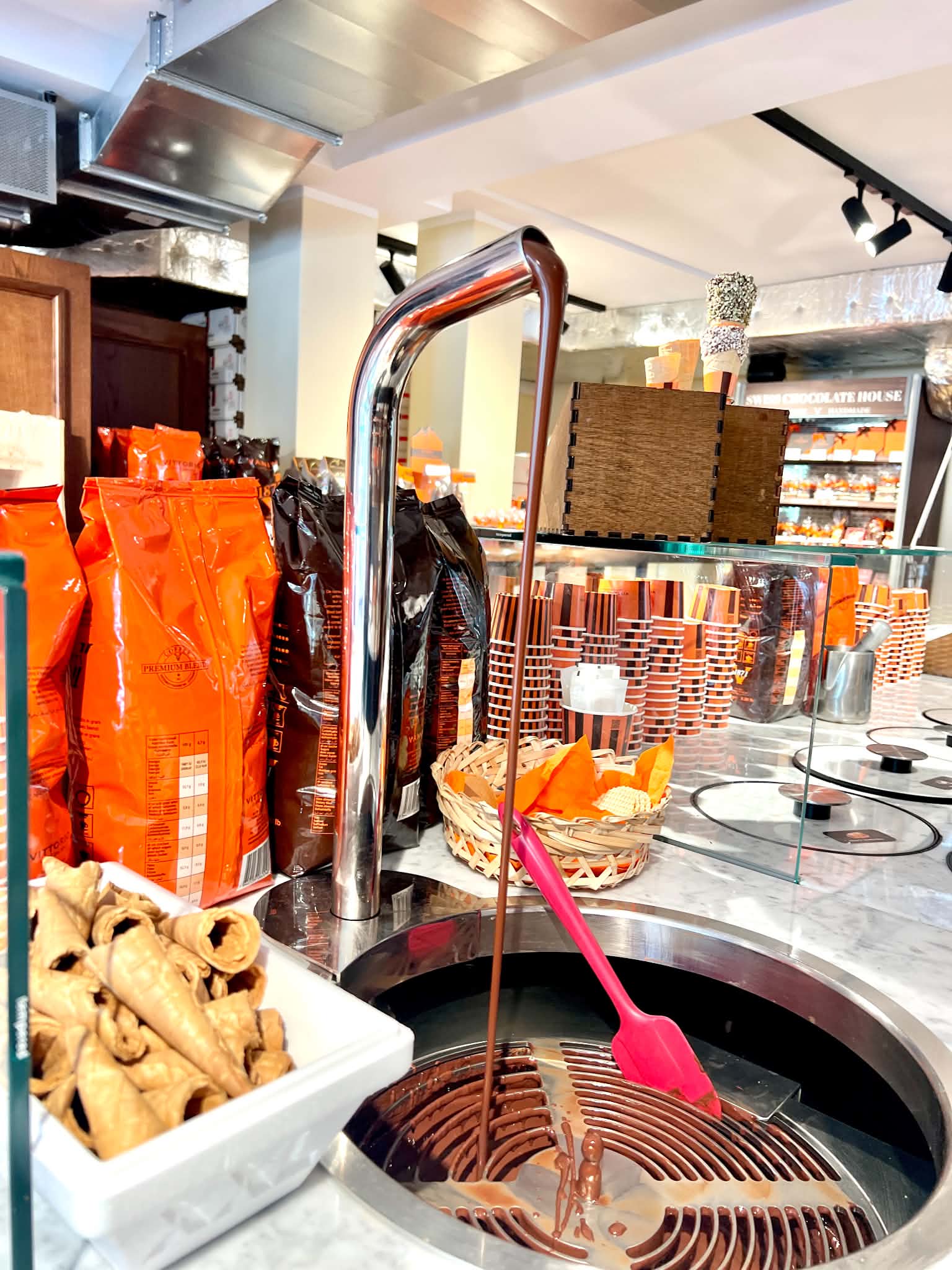 A chocolate fountain inside this chocolate shop.