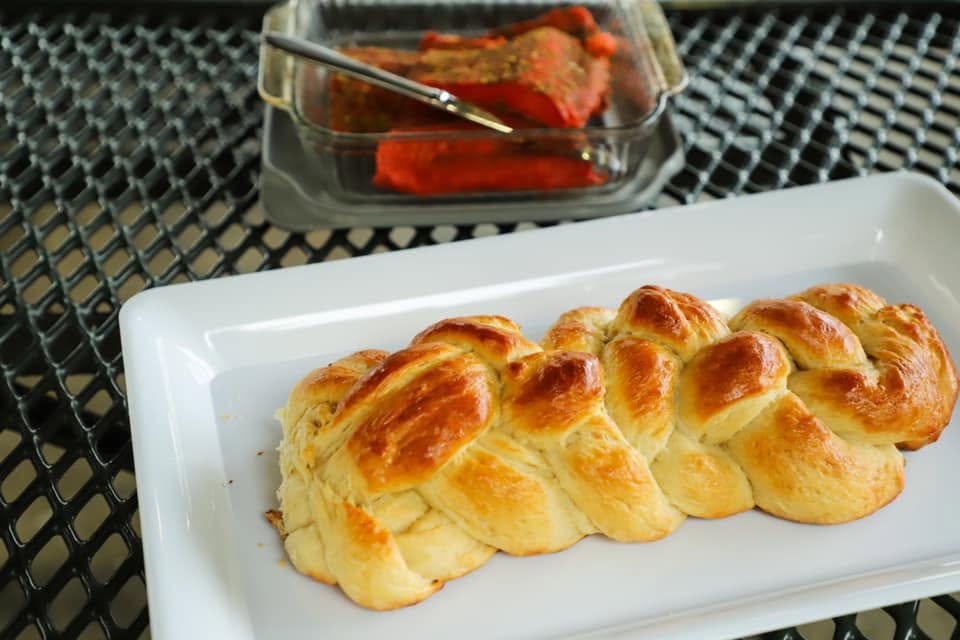 Challah bread displayed on a white platter.