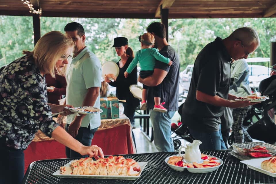 Feast of Trumpets is all about Jesus - Tables full of food with people making their plates.