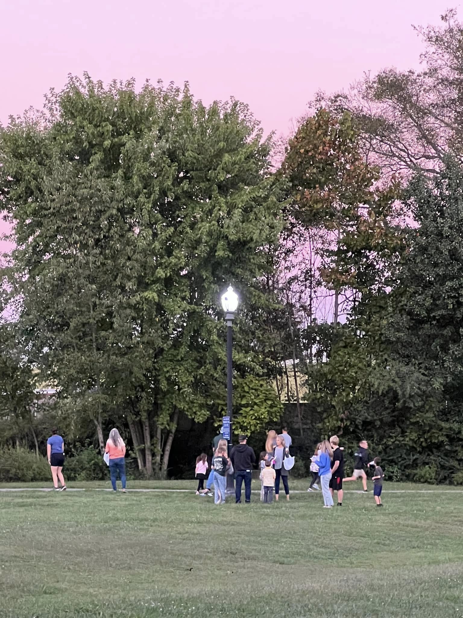 Families finding clues in the park at the Feast of Trumpets scavenger hunt.